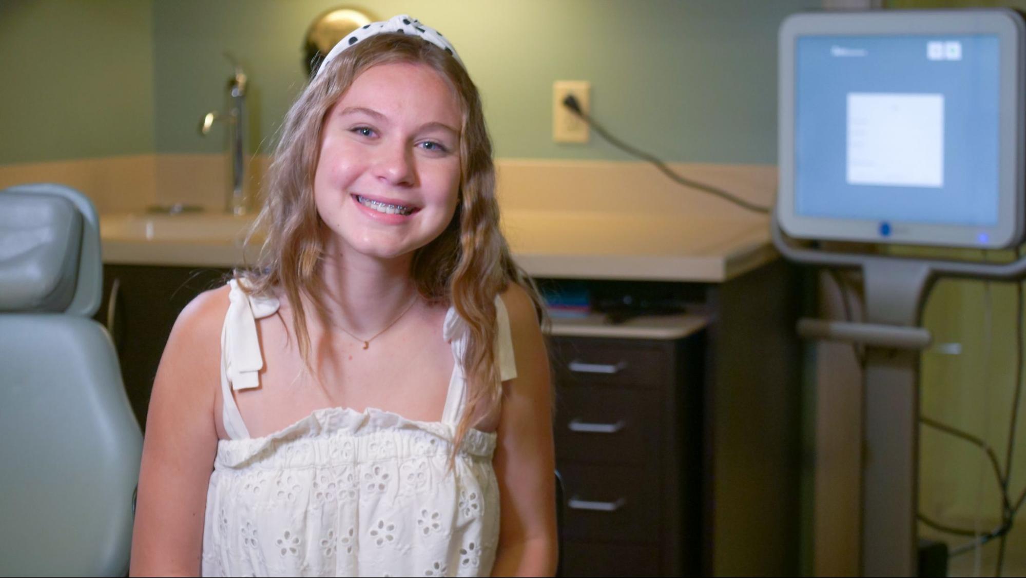 Smiling girl with braces in orthodontic office, showcasing confidence and comfort, emphasizing expert care at Serrano Orthodontics.
