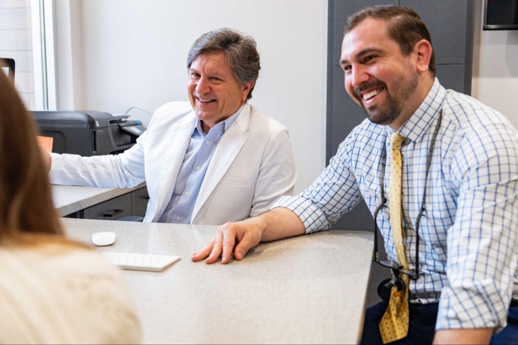 Orthodontists Dr. Paul Serrano and Dr. Andrew Serrano consulting with a patient about retainer care and routines at Serrano Orthodontics.